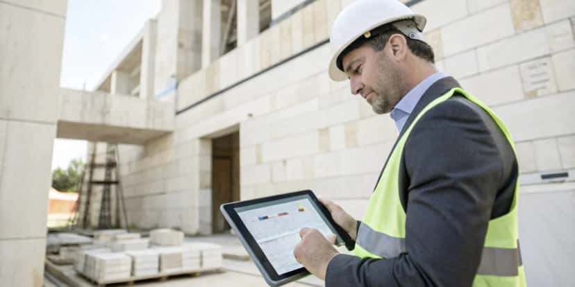 Director de obra usando tablet para seguimiento de proyecto de piedra en construcción de piedra natural
